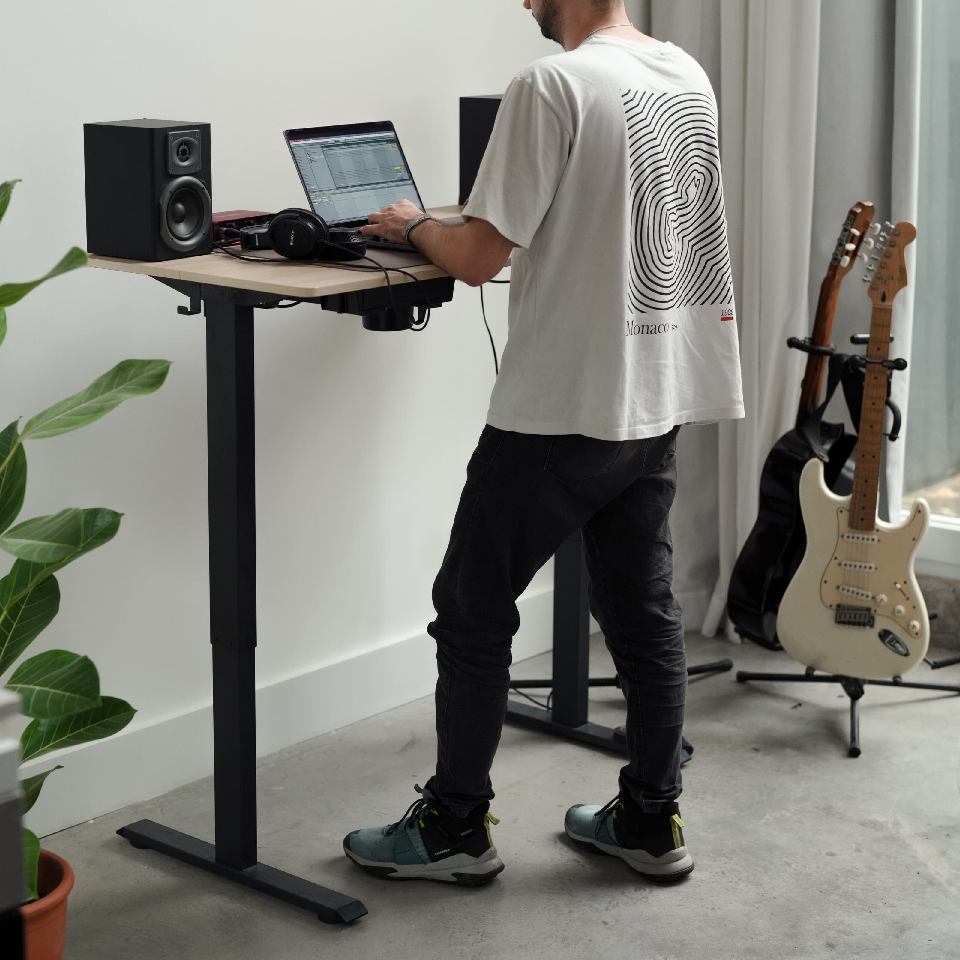 Standing desk NEONIX en un espacio de trabajo con monitor y accesorios