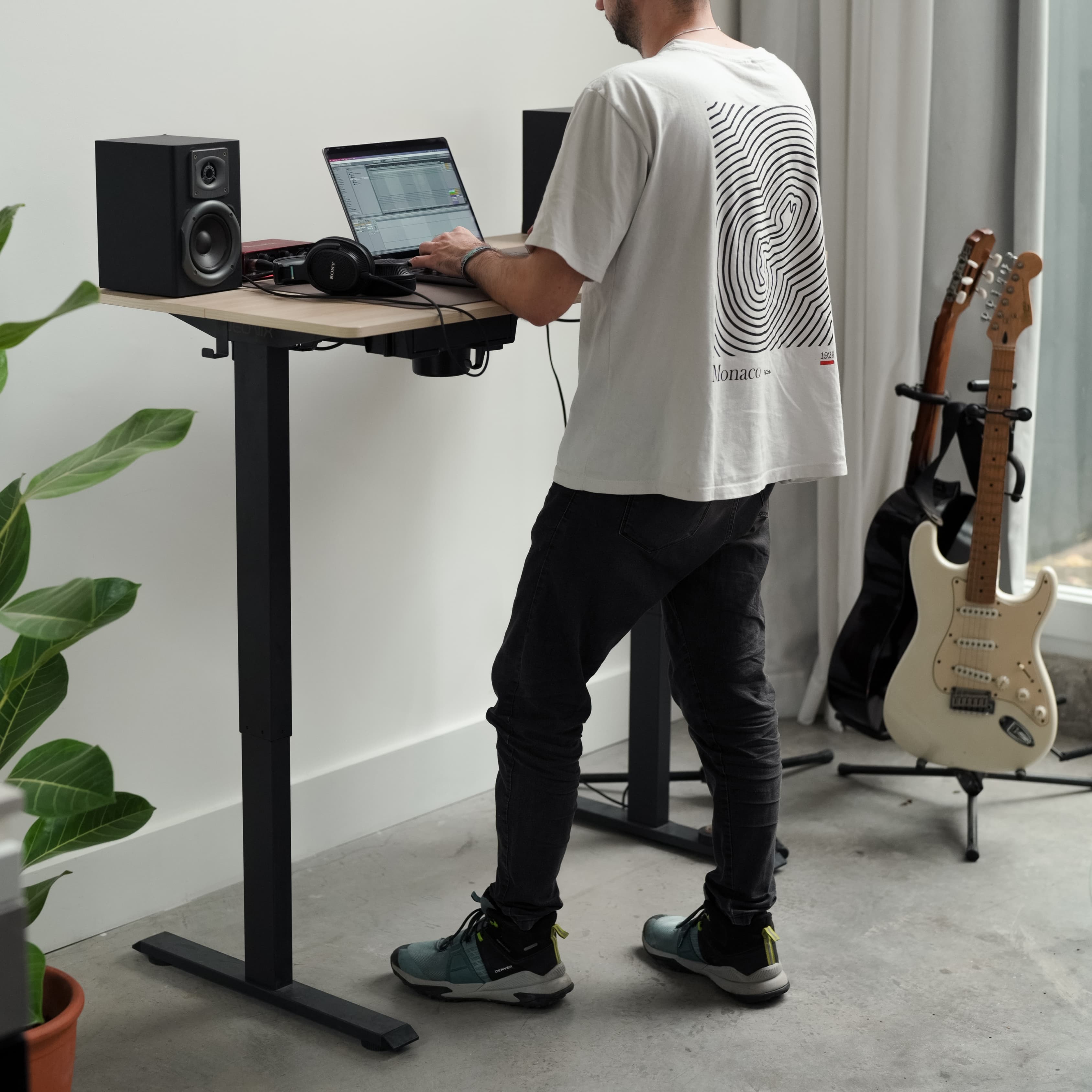 Standing desk NEONIX en un espacio de trabajo con monitor y accesorios